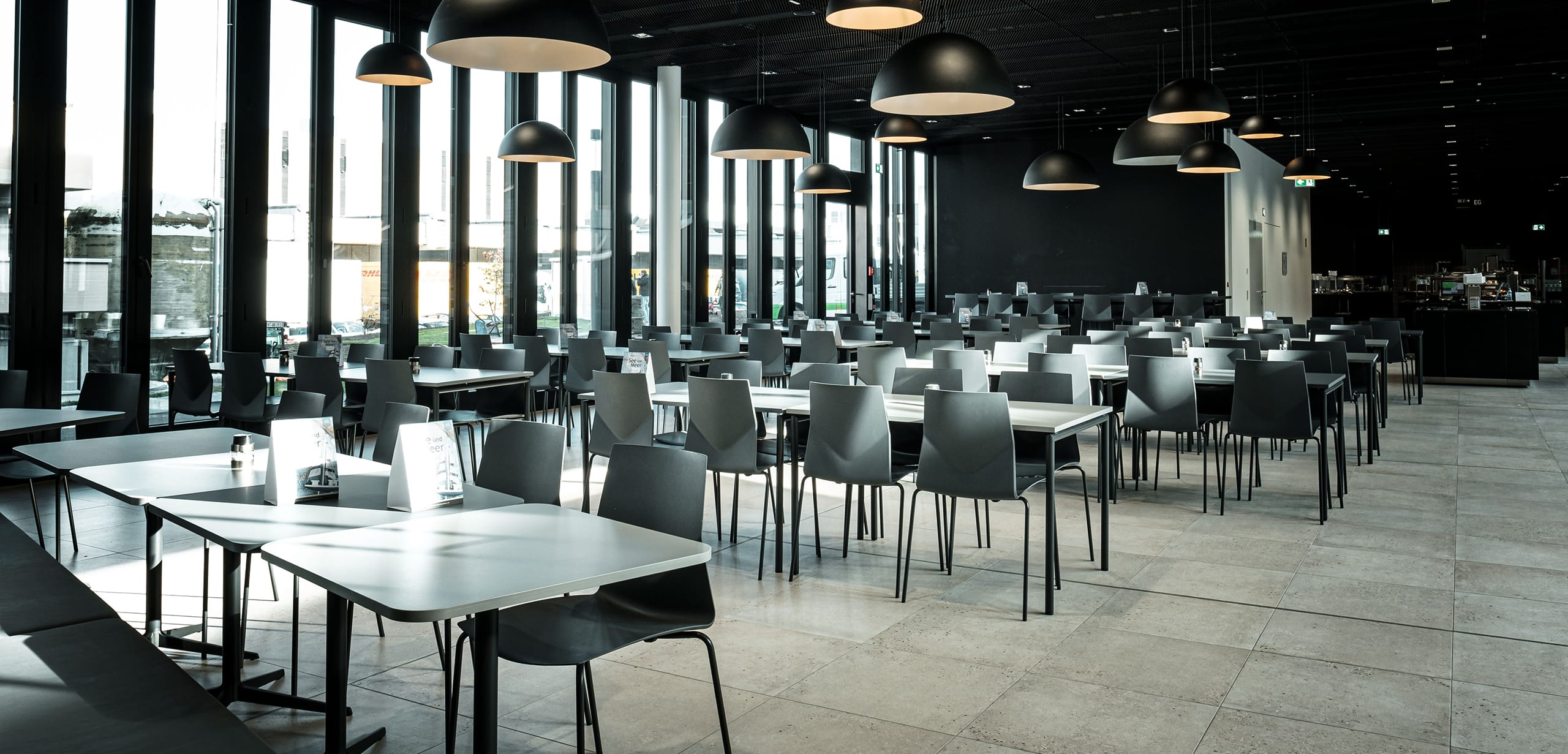 A canteen with canteen furniture and black walls.